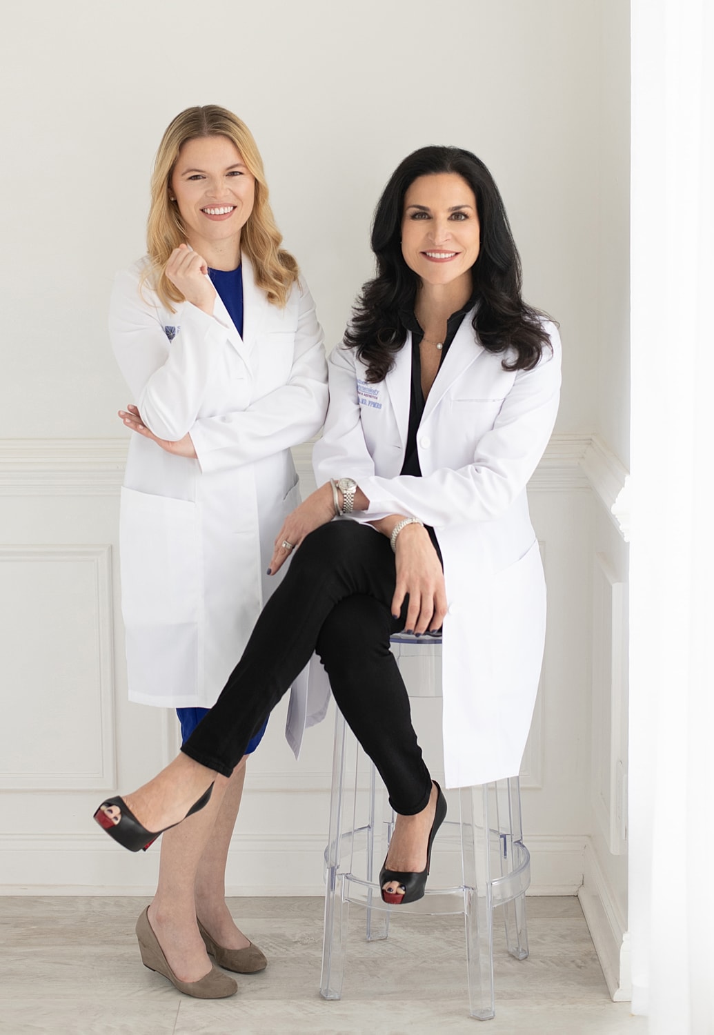 Two confident women in white lab coats.